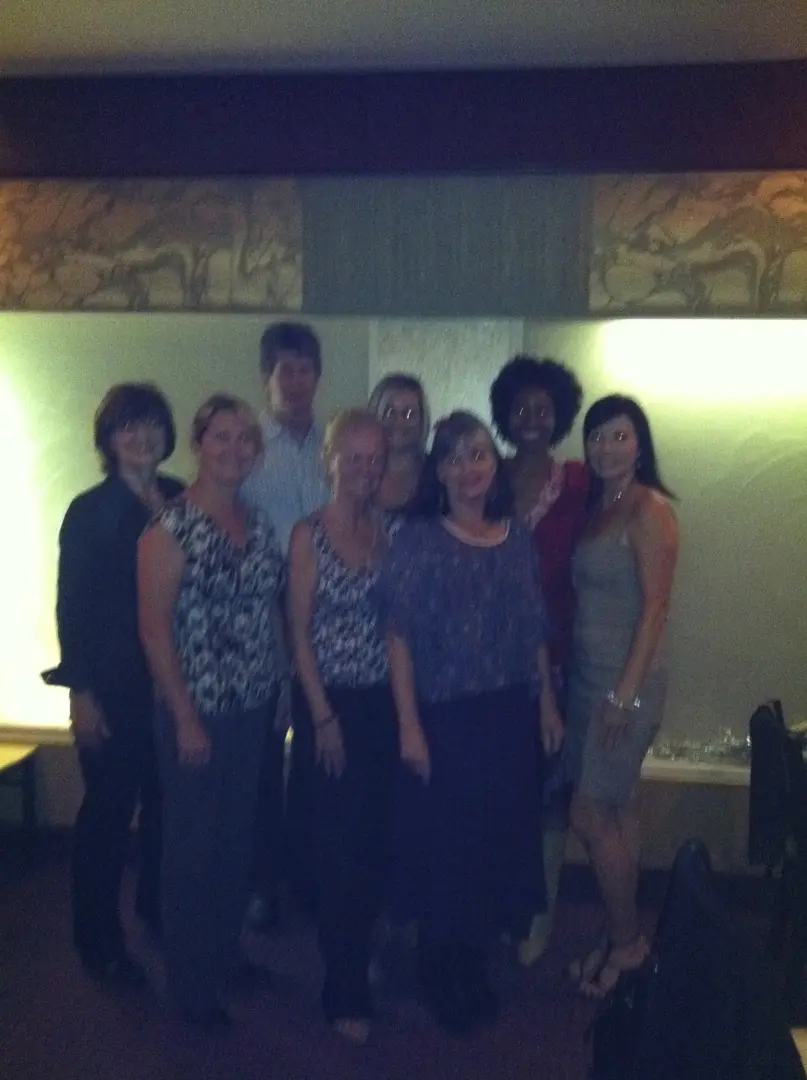 Smiling individuals in a dimly lit room